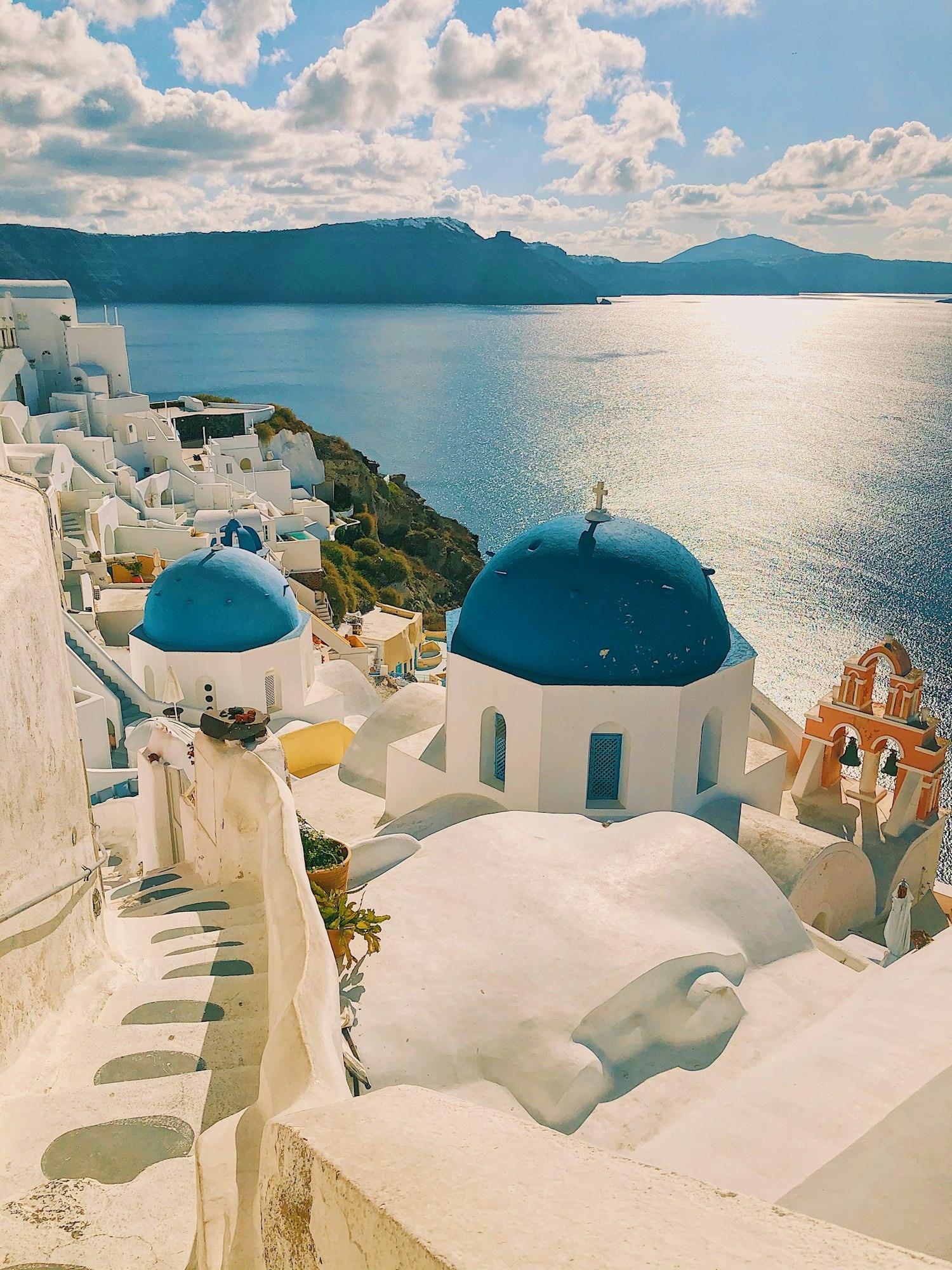 Casas blancas y cúpulas azules frente al mar en Santorini, Grecia