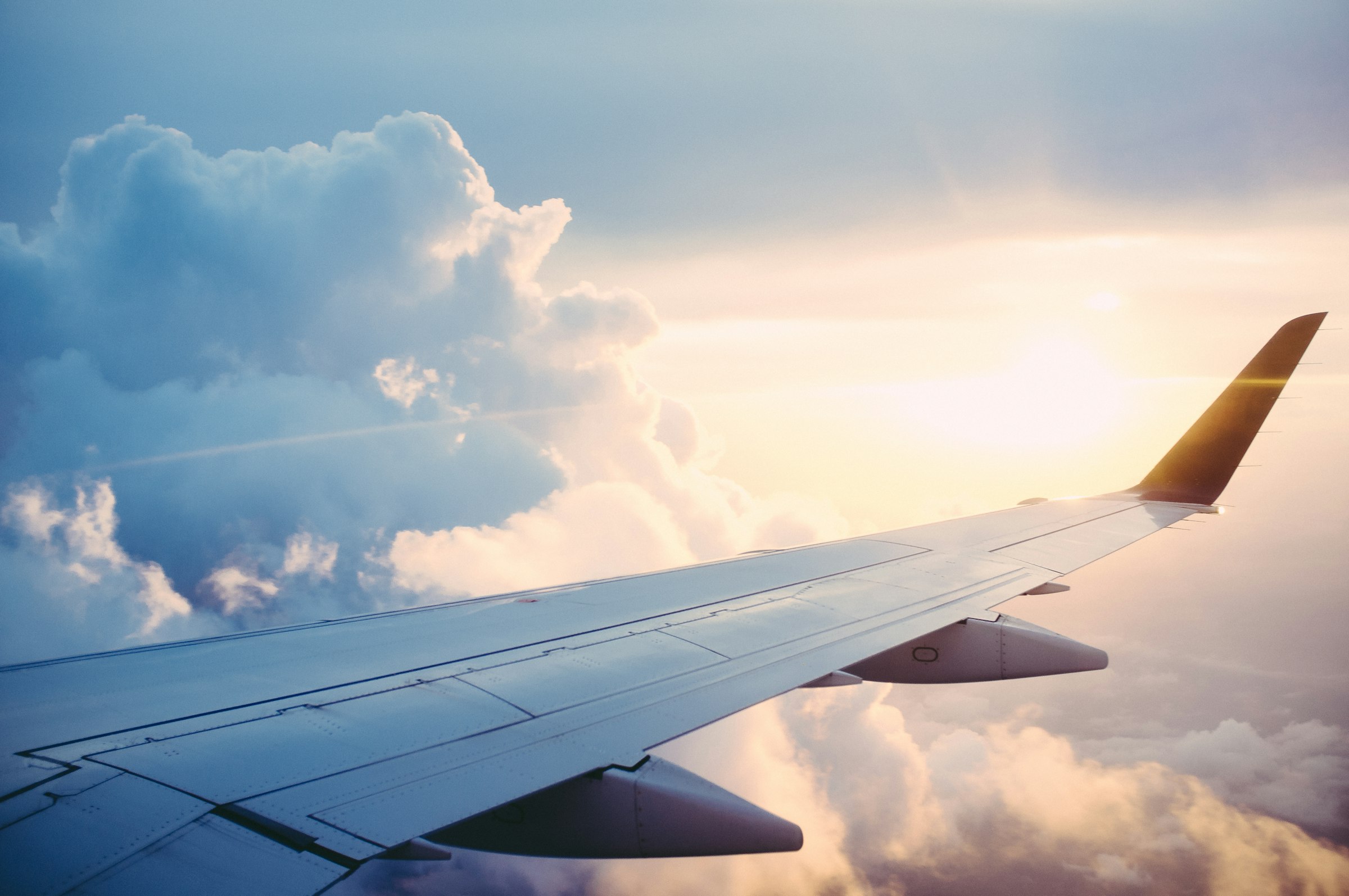 Ala de avión entre las nubes al atardecer, rumbo a tu próximo destino